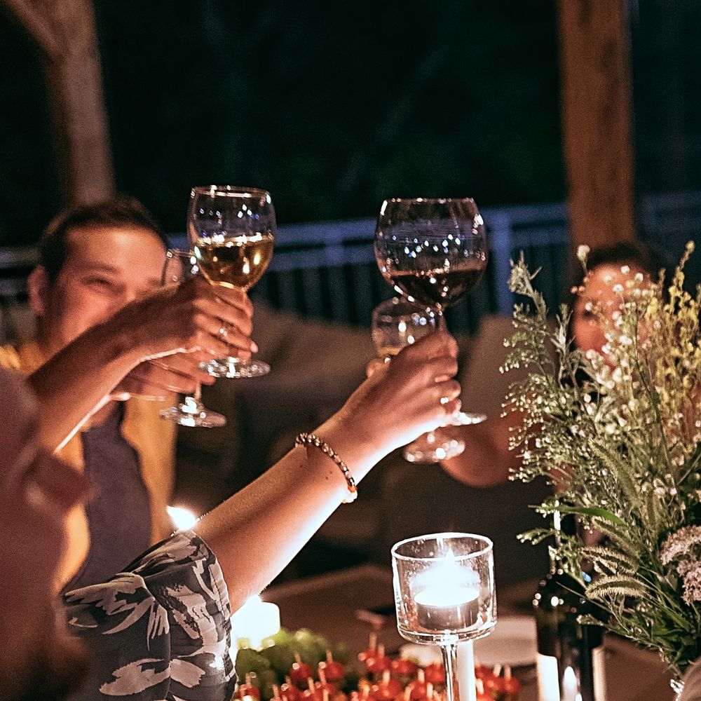 Osoby stykają kieliszki z białym winem na imprezie firmy